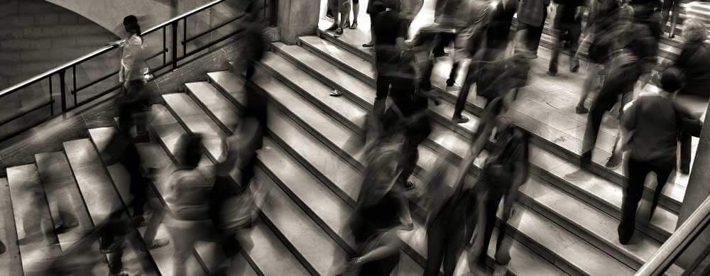 Many people walking fast on staircase