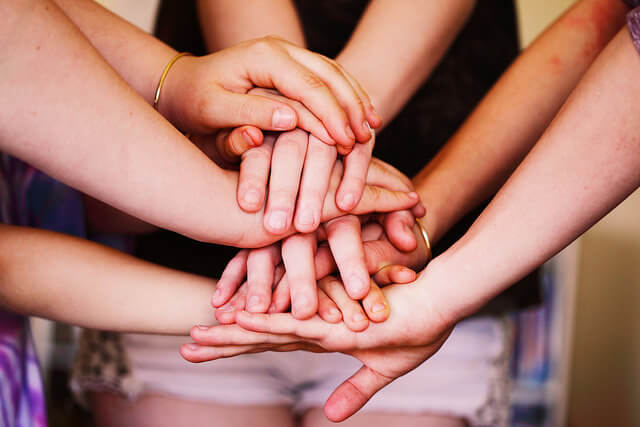 Many human hands on top of one another