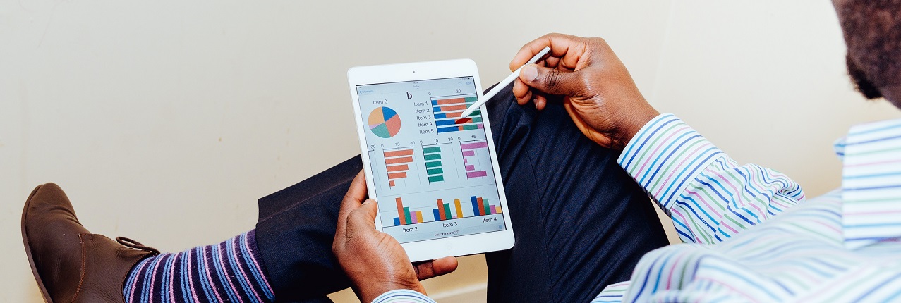 Marketing professional sat looking at tablet displaying various campaign results