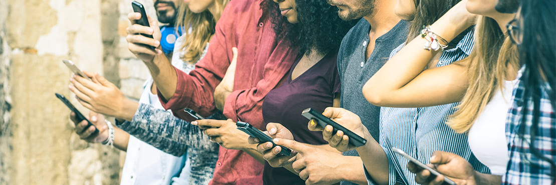 A group of young people all using their mobile phone to browse the internet