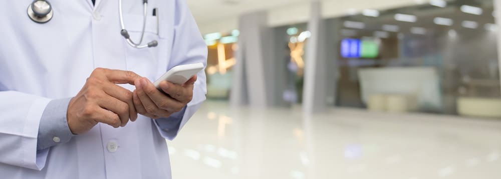 Doctor with a mobile phone reading a text message