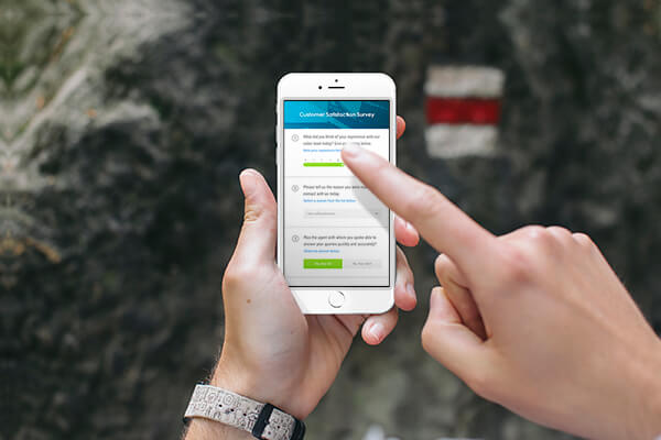 One hand holding a smartphone with an index figure pointing at the screen