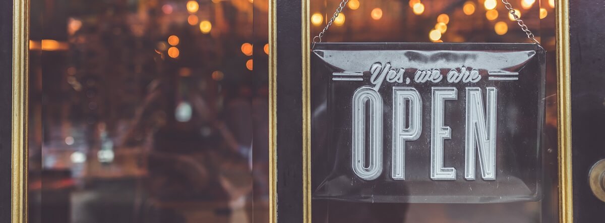 Store front of a retail shop with a signage saying yes we are open