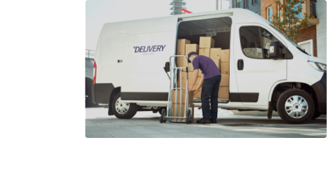 Delivery man loading boxes from van to trolley